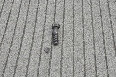 A small metal fragment on grooved runway pavement.